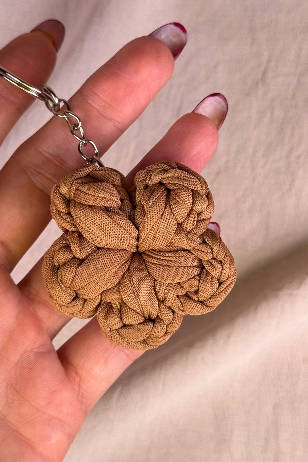 Dettaglio ravvicinato del portachiavi fiore nocciola Made By Hand, che mette in evidenza la texture naturale e la lavorazione artigianale