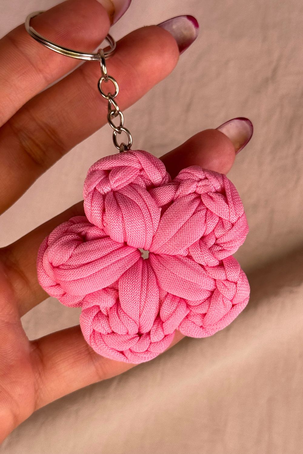 Dettaglio ravvicinato del portachiavi fiore rosa Made By Hand, che mostra la texture morbida e i dettagli realizzati all’uncinetto