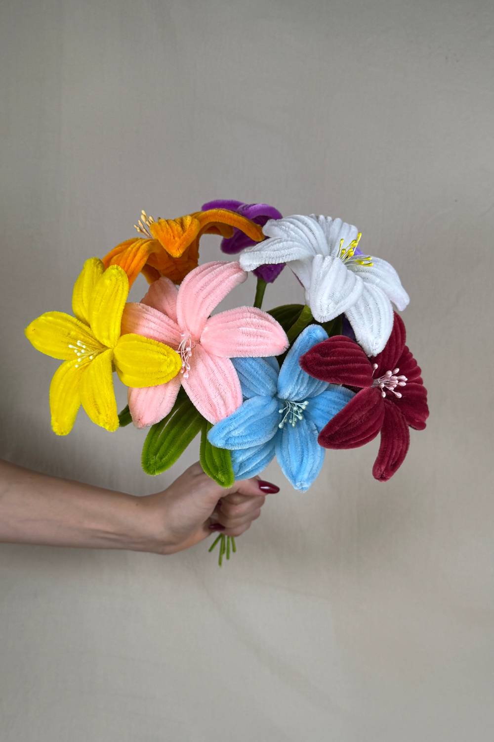 Mazzo di Gigli_in_Scovolini_34cm_Fatto_a_Mano_Made_By_Hand_tenuto in mano su uno sfondo neutro