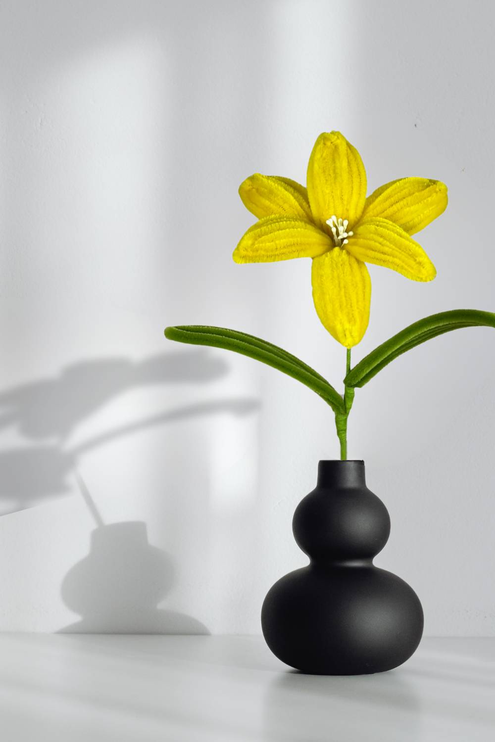 Giglio giallo in scovolini in un vaso nero su sfondo neutro - il fiore è fatto a mano 34 cm – fiore artigianale decorativo realizzato in Italia da Made By Hand.