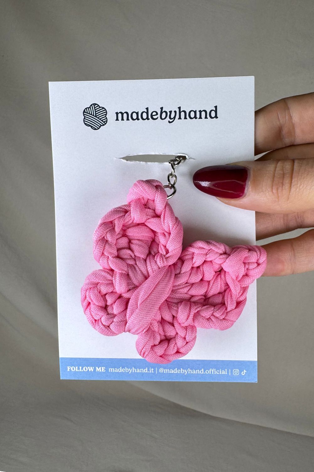 Portachiavi farfalla rosa Made By Hand, in fettuccia all’uncinetto, confezionato su cartoncino bianco con logo, dolce e delicato, perfetto come bomboniera o regalo