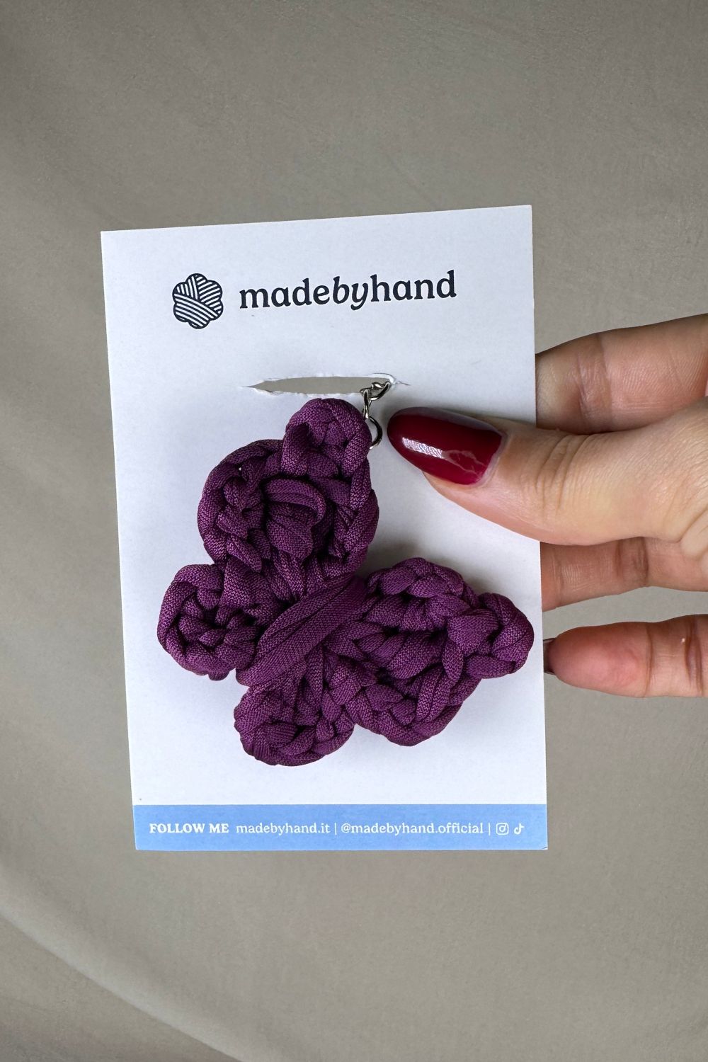 Portachiavi farfalla viola Made By Hand, in fettuccia all’uncinetto, su cartoncino bianco con logo, perfetto come bomboniera o pensiero artigianale