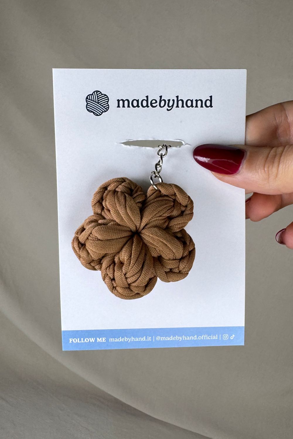 Portachiavi fiore nocciola all’uncinetto Made By Hand, confezionato su cartoncino bianco con logo, in stile naturale e minimal