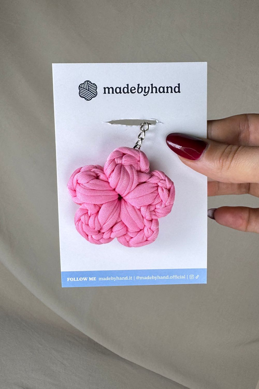 Portachiavi fiore rosa all’uncinetto Made By Hand, confezionato su cartoncino bianco con logo, dolce e romantico, perfetto come bomboniera o pensiero artigianale