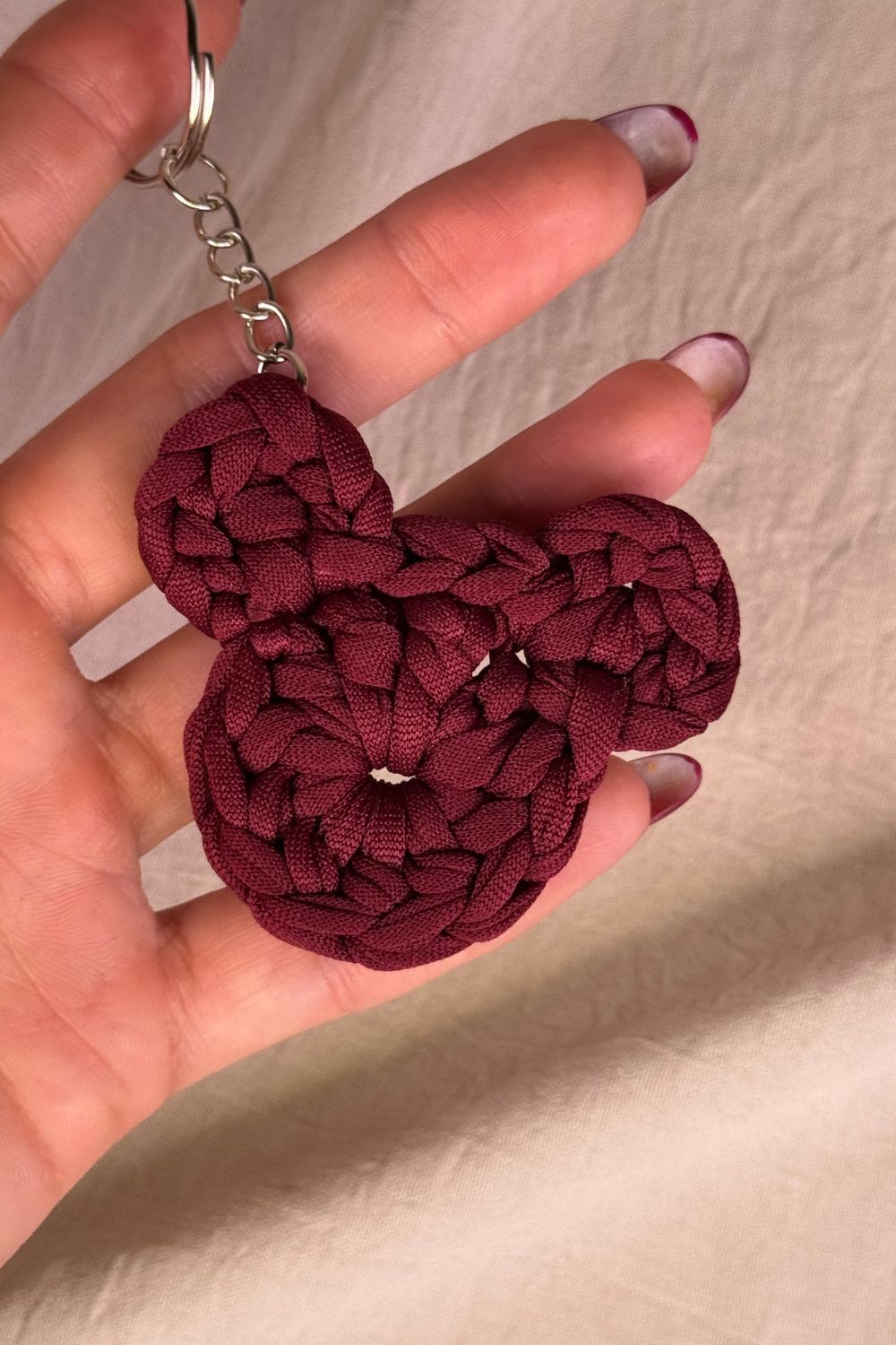Dettaglio ravvicinato del portachiavi orsetto bordeaux all’uncinetto Made By Hand, che mette in risalto la trama e la qualità artigianale