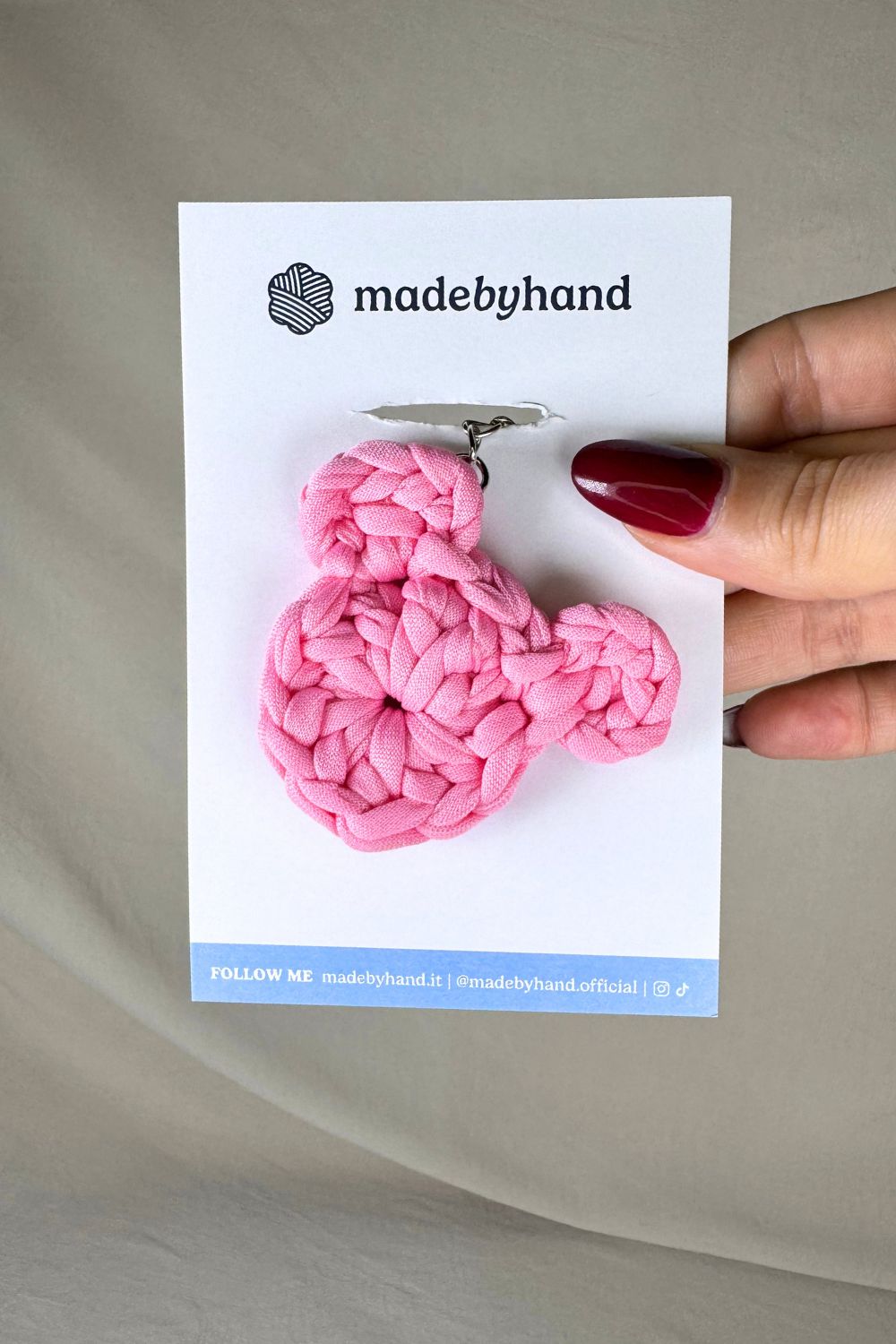 Portachiavi orsetto rosa all’uncinetto Made By Hand, confezionato su cartoncino bianco con logo, dolce e romantico, perfetto come bomboniera o pensiero artigianale