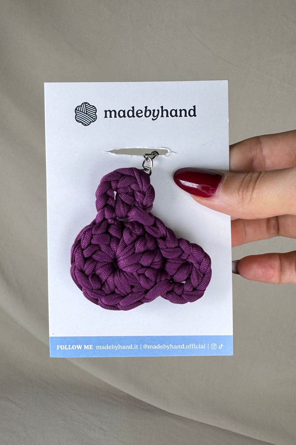 Portachiavi orsetto viola all’uncinetto Made By Hand, su cartoncino bianco con logo, perfetto come bomboniera o pensiero artigianale