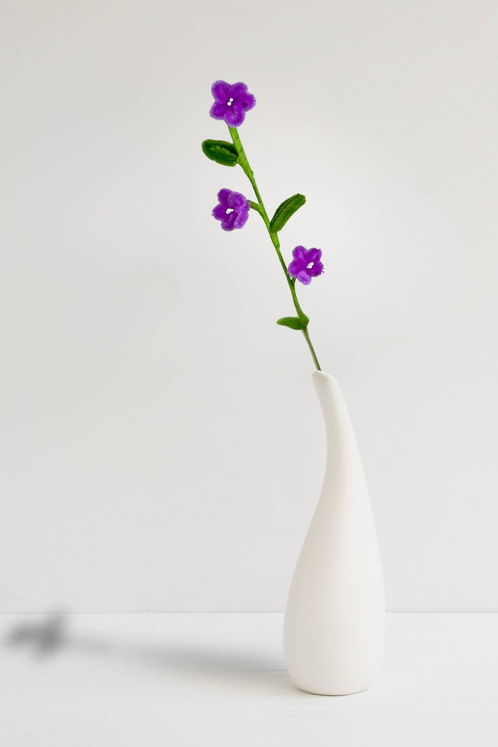 n un vaso, un rametto con 3 mini margherite magenta in scovolini, fatto a mano da Made By Hand in Italia, fiore artigianale decorativo 34 cm ideale per mazzi o regali floreali sostenibili