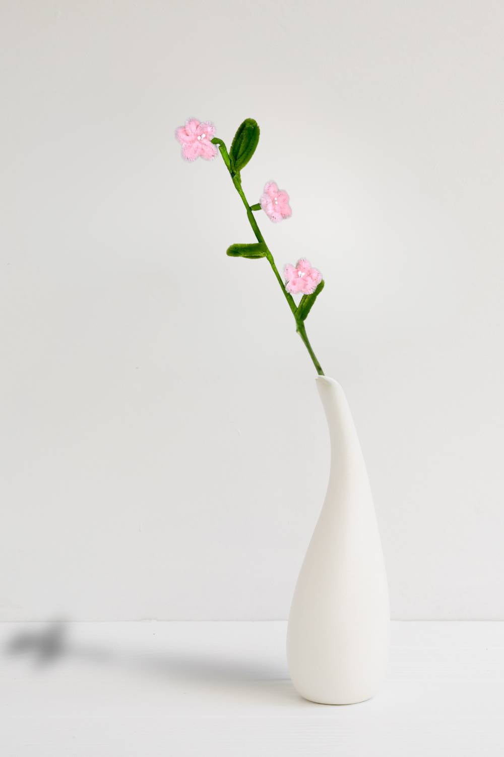 In un vaso, un rametto con 3 mini margherite rosa chiaro in scovolini, fatto a mano da Made By Hand in Italia, fiore artigianale decorativo 34 cm ideale per mazzi o regali floreali sostenibili