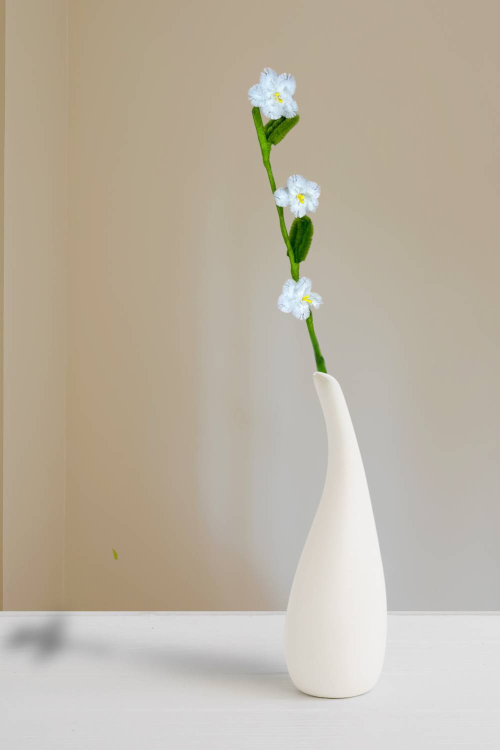 n un vaso, un rametto con 3 mini margherite bianche in scovolini, fatto a mano da Made By Hand in Italia, fiore artigianale decorativo 34 cm ideale per mazzi o regali floreali sostenibili. Made by hand crea fiori con scovolini colorati fatti a mano in italia.
