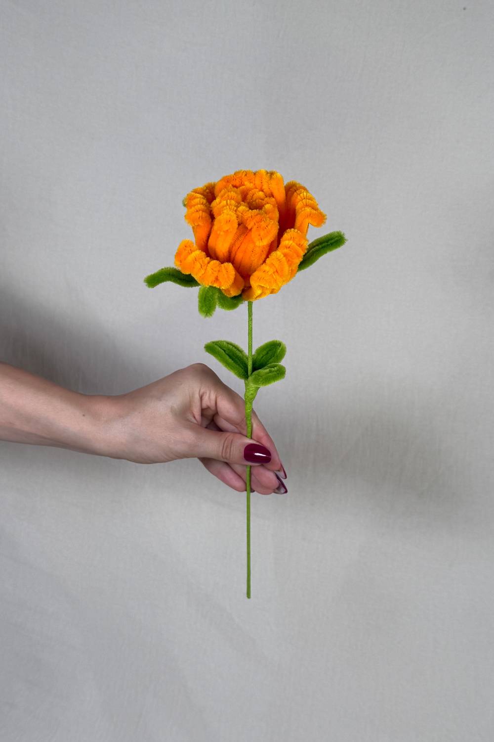 Rosa arancione in scovolini artigianale Made By Hand tenuta in mano per mostrare le dimensioni reali, fiore fatto a mano con cura e materiali di qualità.