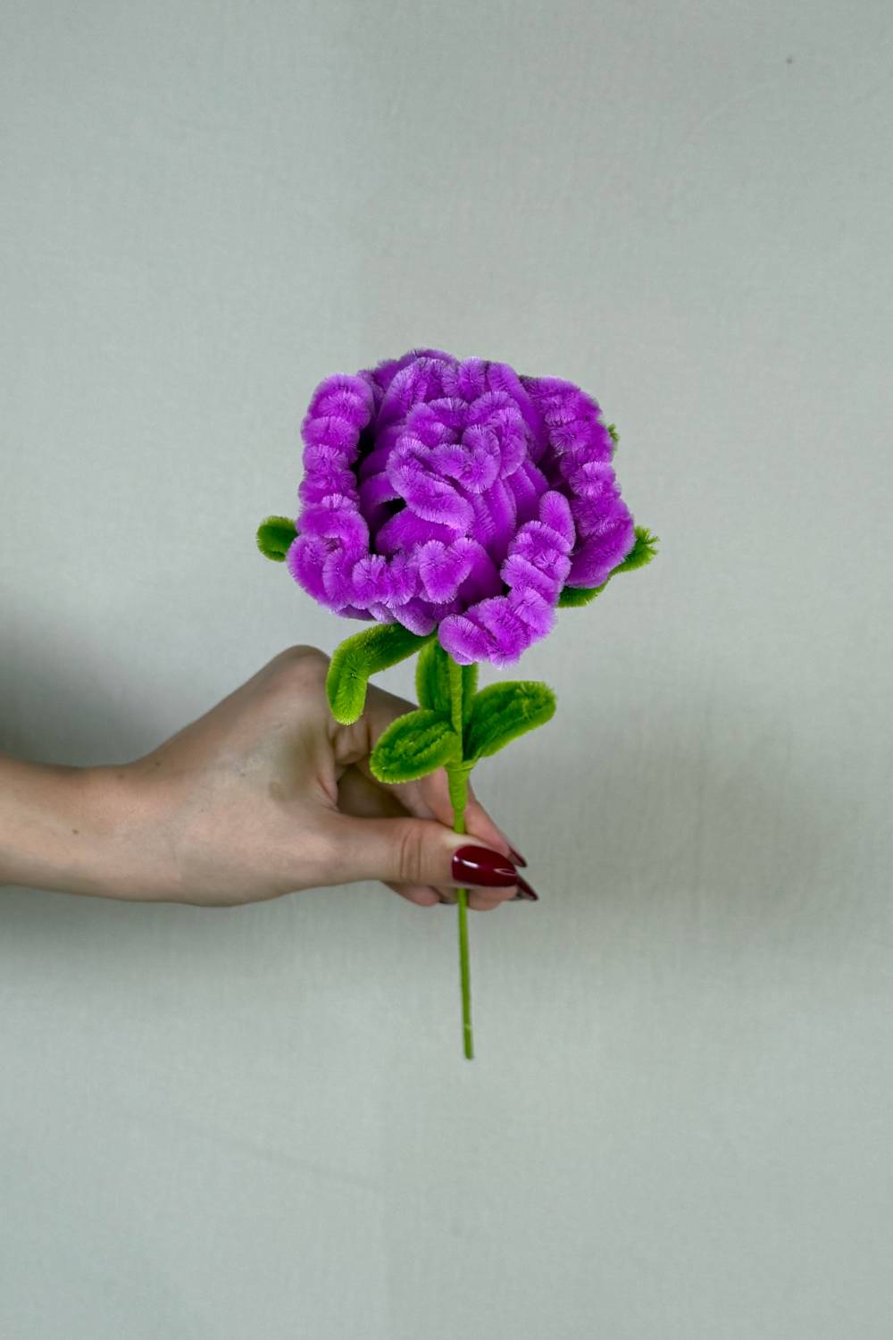 Rosa viola in scovolini artigianale Made By Hand tenuta in mano per mostrare le dimensioni reali, fiore fatto a mano con cura e materiali di qualità. Made By Hand crea fiori fatti con scovolini a mano in Italia
