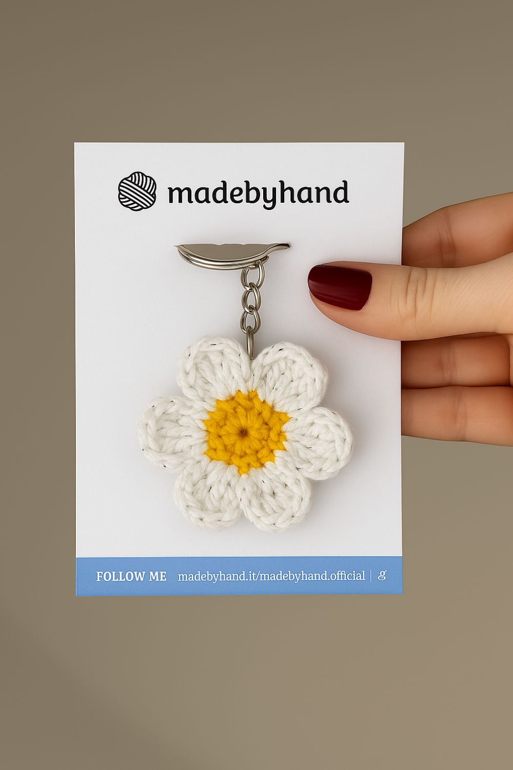 Portachiavi a margherita realizzato all’uncinetto, fatto a mano in Italia da Made By Hand, mostrato in mano per evidenziare i dettagli artigianali e la dimensione reale