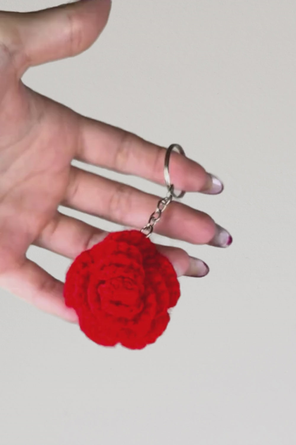 Video 360° del portachiavi con rosa rossa fatto a mano in Italia da Made By Hand, creazione artigianale all’uncinetto mostrata in rotazione per evidenziare i dettagli del fiore