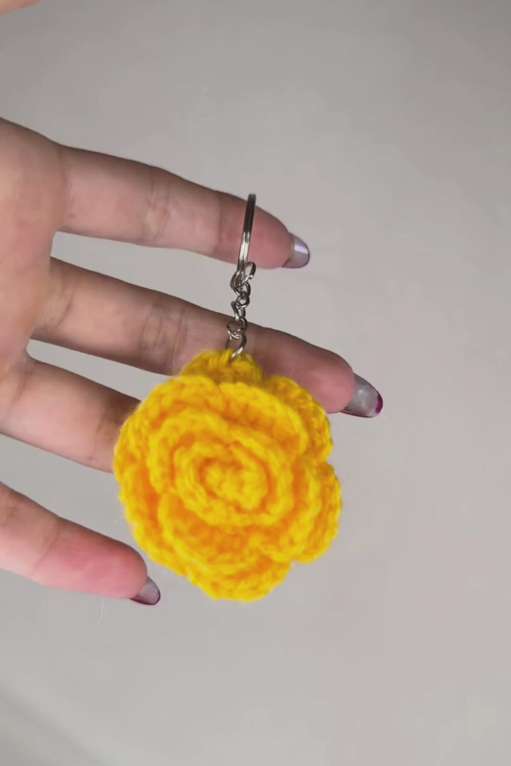Video 360° del portachiavi con rosa gialla fatto a mano in Italia da Made By Hand, creazione artigianale all’uncinetto mostrata in rotazione per evidenziare i dettagli del fiore