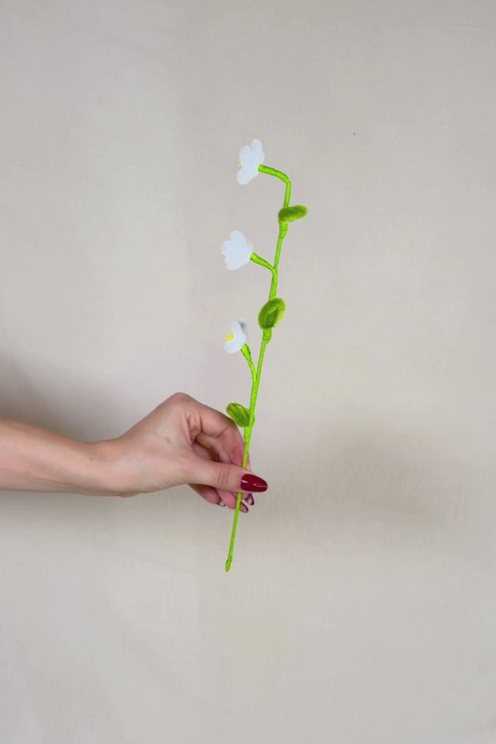 Video che fa vedere a 360 gradi un rametto con 3 mini margherite bianche in scovolini, fatto a mano da Made By Hand in Italia, fiore artigianale decorativo 34 cm ideale per mazzi o regali floreali sostenibili