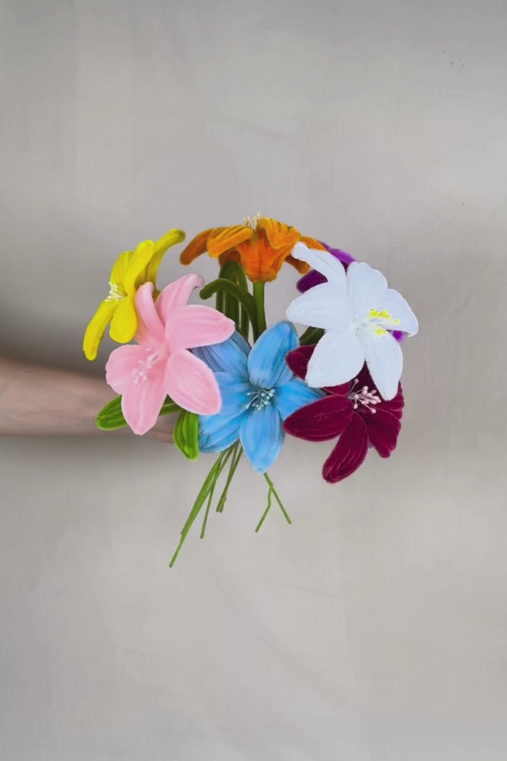 Video di un Mazzo di Gigli_in_Scovolini_34cm_Fatto_a_Mano_Made_By_Hand_tenuto in mano su uno sfondo neutro