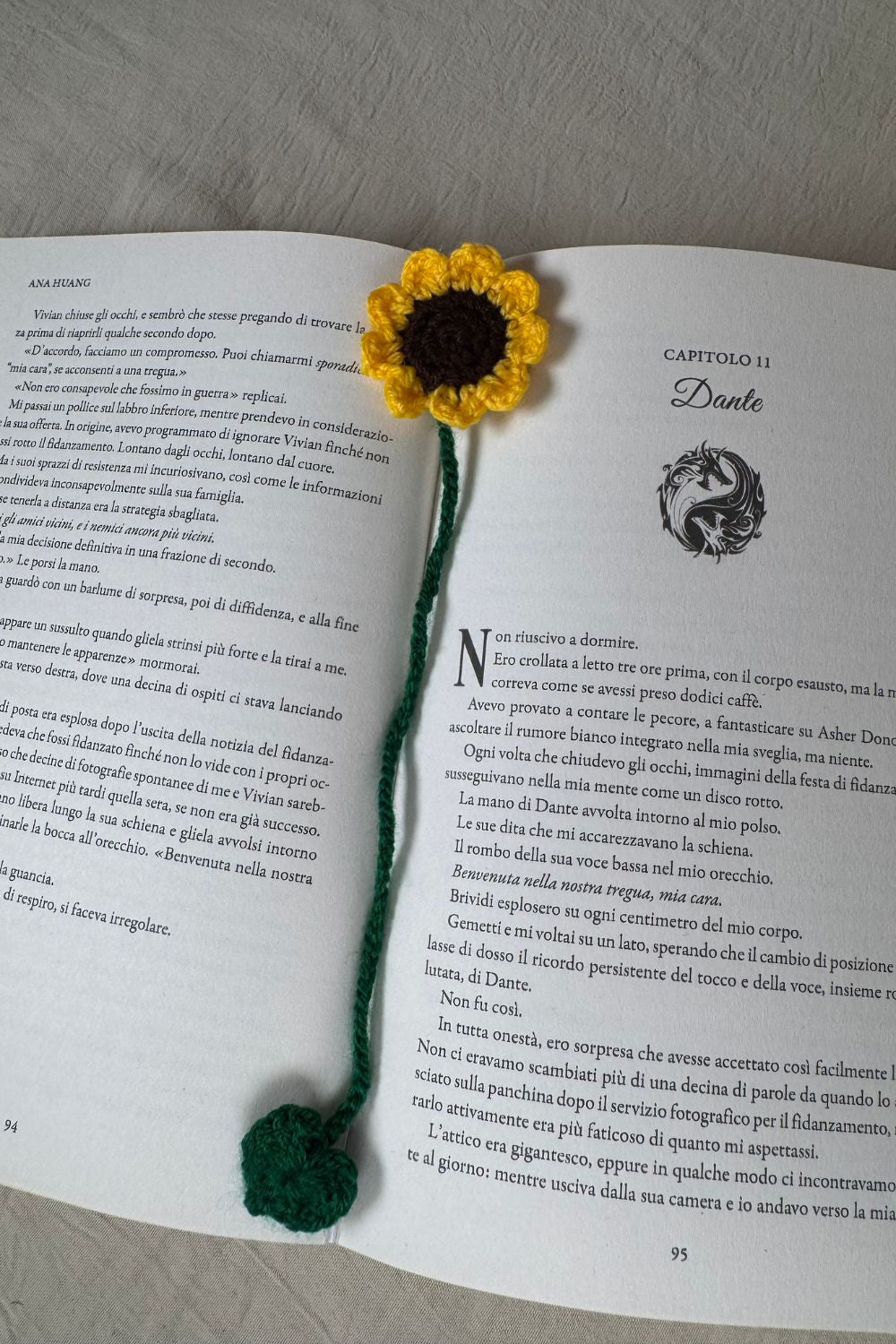 Segnalibro Girasole all’uncinetto Made By Hand visto dall’alto su libro aperto, fiore artigianale realizzato a mano in Italia, accessorio originale per lettori e amanti dell’artigianato