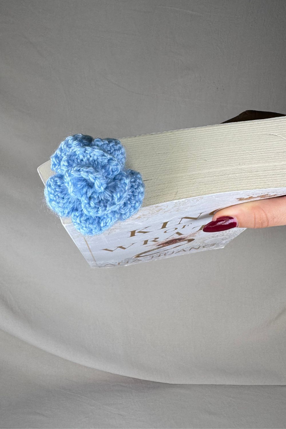 Segnalibro Rosa Azzurra all’uncinetto fatto a mano in Italia da Made By Hand, accessorio artigianale per libri con fiore giallo e gambo verde, idea regalo sostenibile per chi ama leggere.