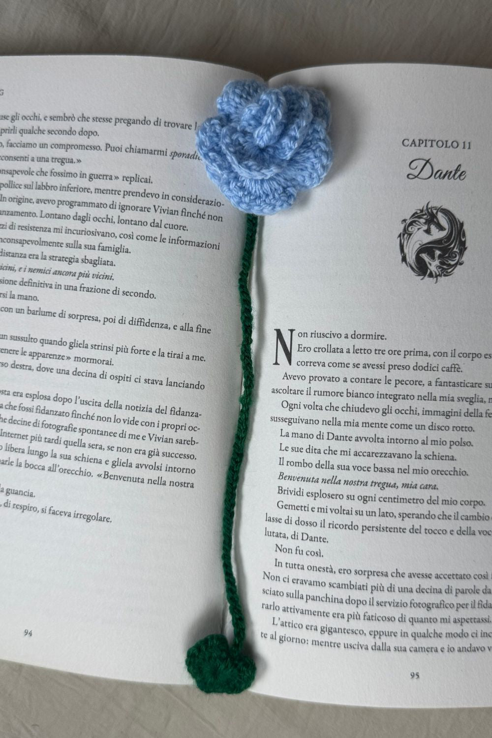 Segnalibro Rosa Azzurra all’uncinetto Made By Hand visto dall’alto su libro aperto, fiore artigianale realizzato a mano in Italia, accessorio originale per lettori e amanti dell’artigianato