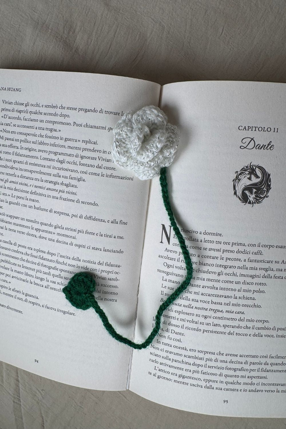 Segnalibro Rosa bianca all’uncinetto Made By Hand visto dall’alto su libro aperto, fiore artigianale realizzato a mano in Italia, accessorio originale per lettori e amanti dell’artigianato