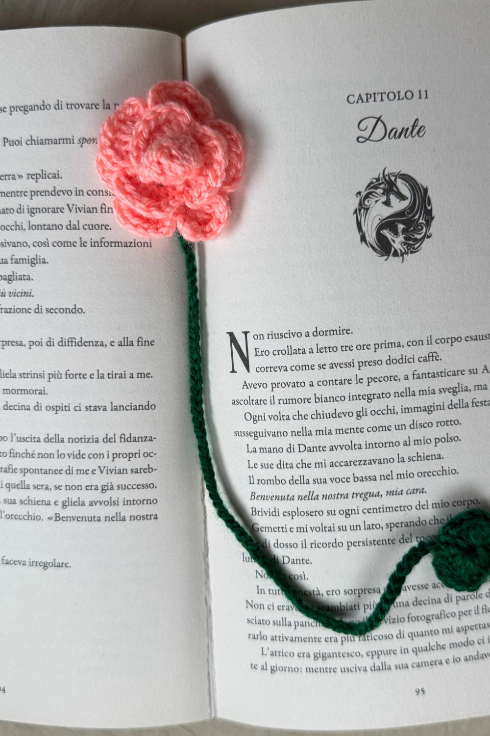 Segnalibro Rosa rosa-salmone all’uncinetto Made By Hand visto dall’alto su libro aperto, fiore artigianale realizzato a mano in Italia, accessorio originale per lettori e amanti dell’artigianato