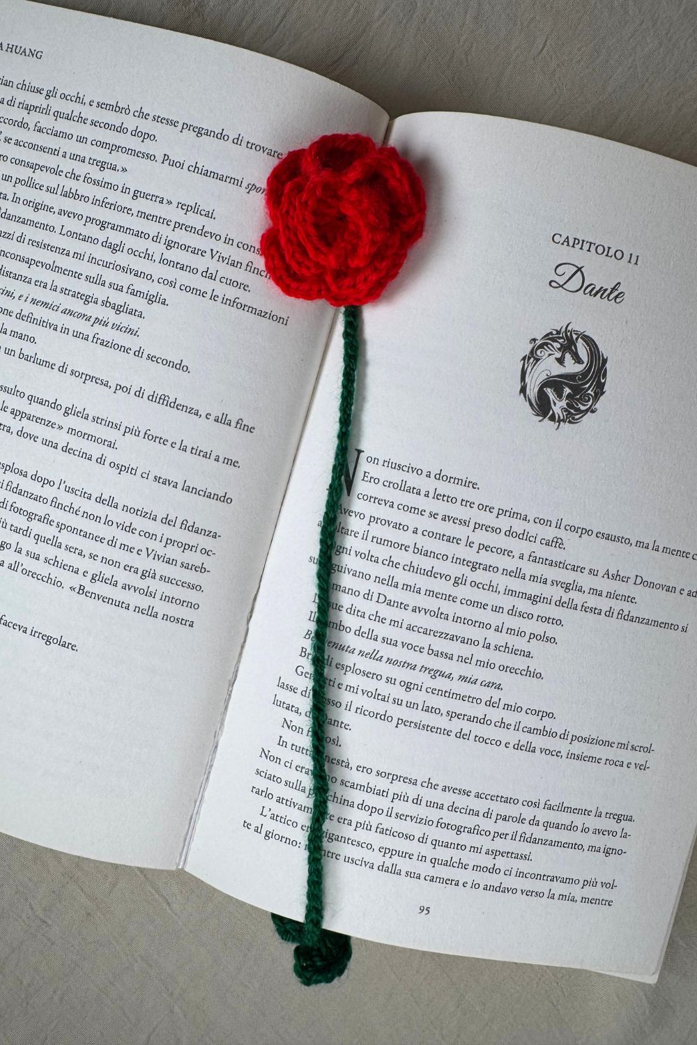 Segnalibro Rosa rossa all’uncinetto Made By Hand visto dall’alto su libro aperto, fiore artigianale realizzato a mano in Italia, accessorio originale per lettori e amanti dell’artigianato