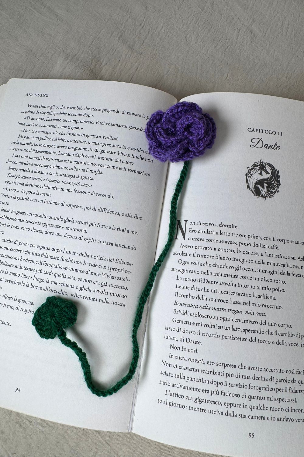 Segnalibro Rosa viola all’uncinetto Made By Hand visto dall’alto su libro aperto, fiore artigianale realizzato a mano in Italia, accessorio originale per lettori e amanti dell’artigianato